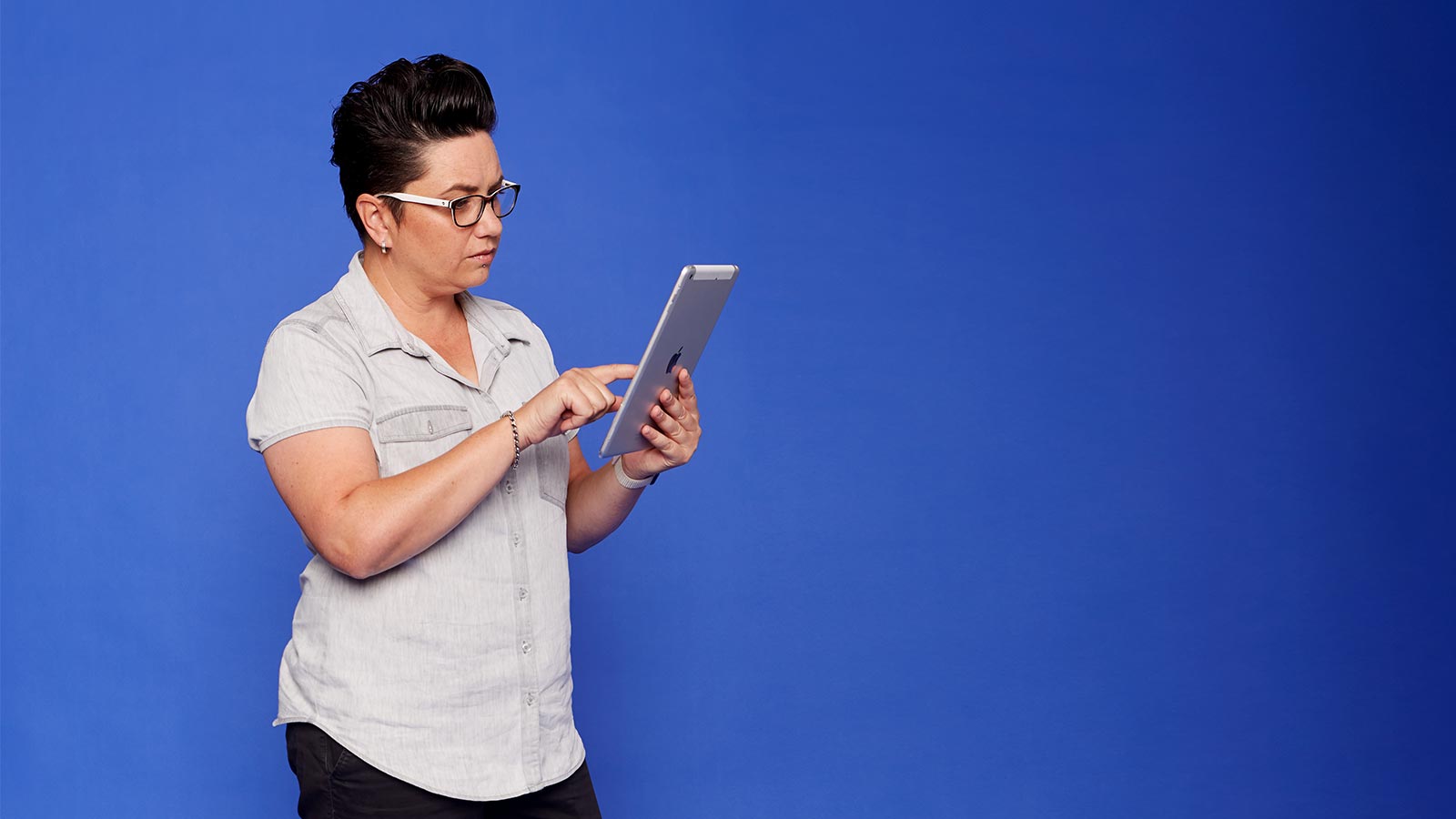 Woman wearing glasses using a tablet.
